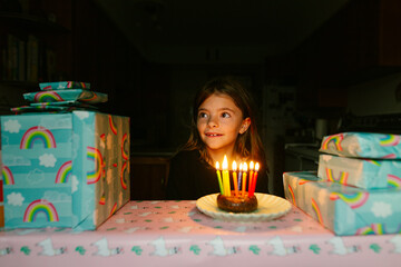 girl sits in front of candles on donut for her birthday