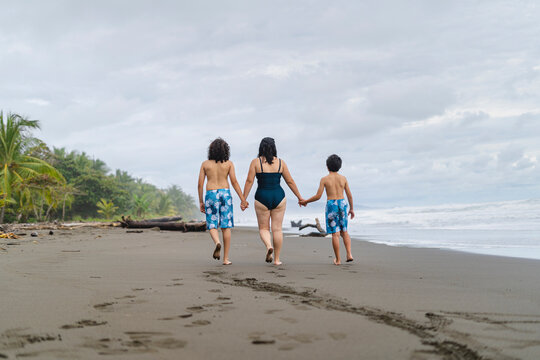 Mother and children walking on the beach. 