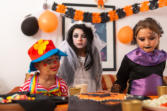 Fancy dressed kids at halloween party table