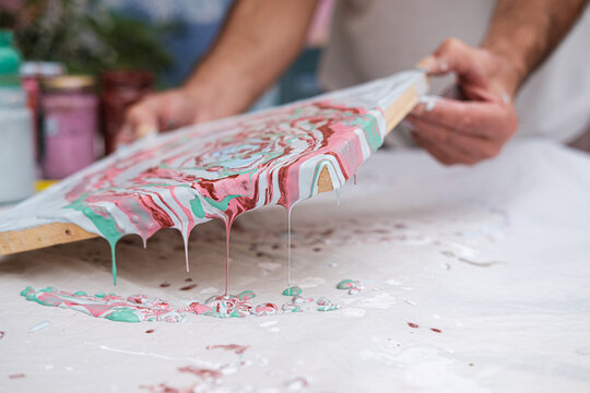 Anonymous artist pouring colorful paint 
