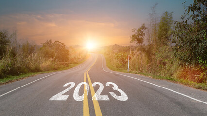 New year 2023 forward concept. Word 2023 written on the asphalt road at sunset sky. Concept of...