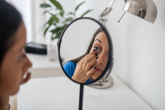 teenage girl putting on contact lenses