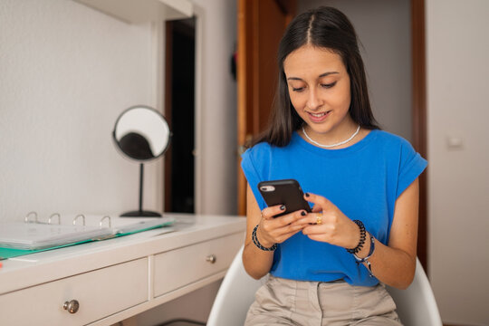 teen girl with mobile phone in her bedroom