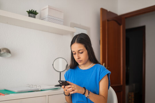 teen girl with mobile phone in her bedroom