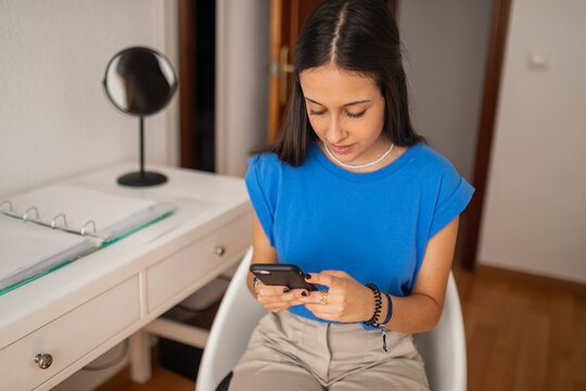 teen girl with mobile phone in her bedroom