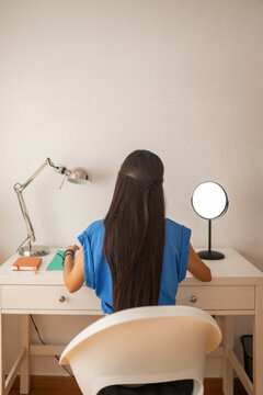teenage girl studying at her bedroom desk