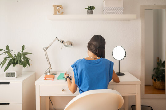 teenage girl studying at her bedroom desk