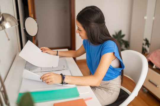 teenage girl studying at her bedroom desk