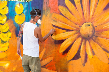 Graffiti artist painting large floral mural