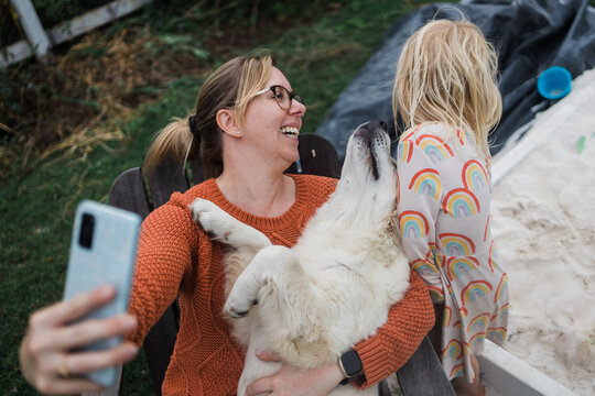 woman taking selfie with dog and girl - Powered by Adobe