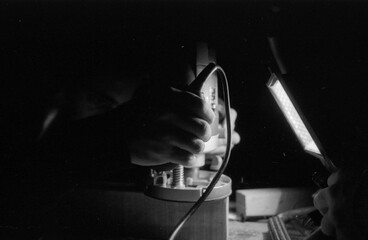 the hands of an unrecognizable carpenter sanding