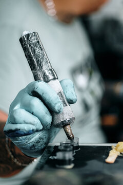 Unrecognizable tattooist loading ink machine