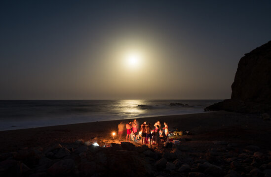 Family enjoying together during night picnic at the beach
