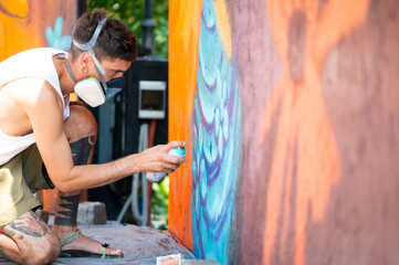 Graffiti artist painting large floral mural