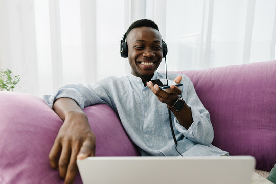 A man talking on the phone on the couch at home