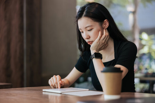 Young woman in a cafe reading an ebook