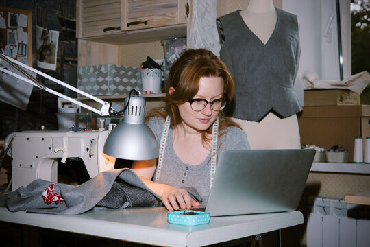 A young atelier woman is working on a tweed jacket design.