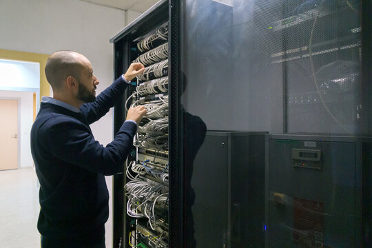 Computer technician man working in a server room