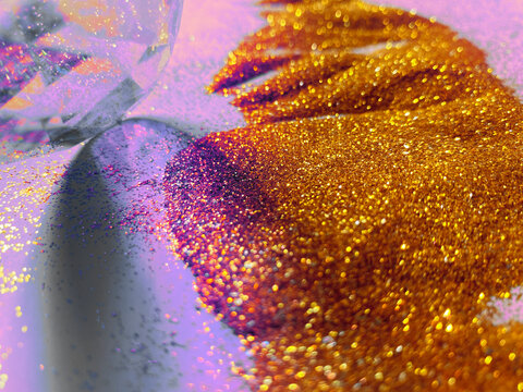 Shadow play of prism lens on the background with golden glitter.