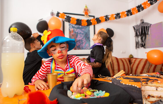 Kid eating sweets at halloween party.