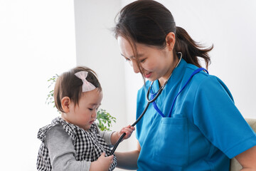 赤ちゃんの診察をする若いドクター
