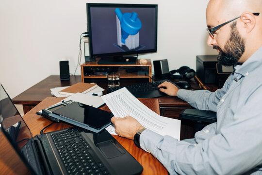 Male engineer working with documents and 3D models