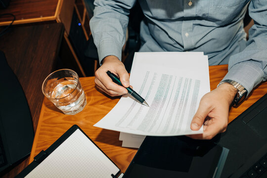 Anonymous man working with paper document at the desk