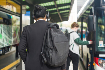 Man with backpack in line to get on the bus
