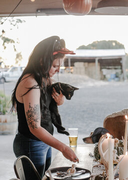 woman wearing devil horn headband holds black cat