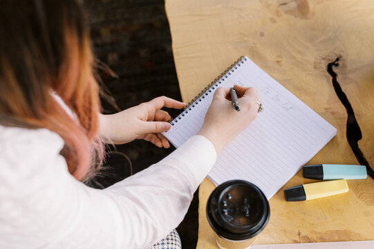 close up of a woman taking notes at a cafe