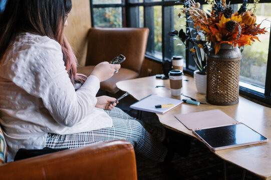 Business woman at a cafe using her smart phone