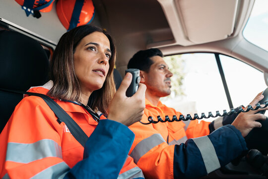 EMs Paramedic with Radio in Ambulance - Powered by Adobe