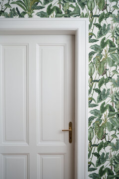 White door surounded by a greenish wallpaper