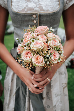 Close up on the hand of a bride with a bridal bouquet 