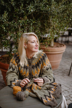 Blonde woman knitting outdoors