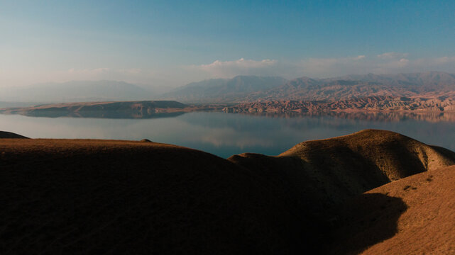 aerial landscape of a blue lake surrounded by mountains at the sunset