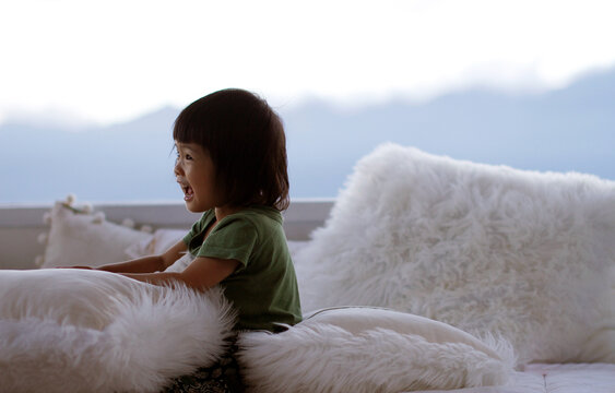 Closeup of a little Asian girl playing with a wool blanket