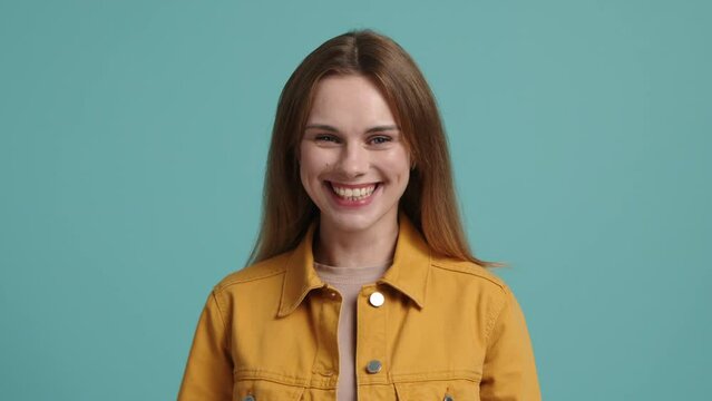 Close-up shot of a cheerful girl in her 30s, wearing casual clothes. Portrait of a young, happy woman looking at camera. High quality 4k footage