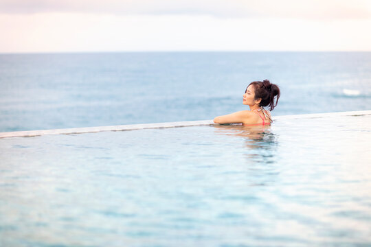 Beautiful woman relaxed and enjoyed nature in infinity pool