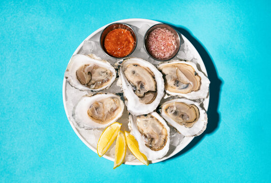 Plate Of Half Dozen Oysters On Blue