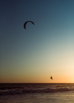 Man silhouette enjoying kitesurf at sunset