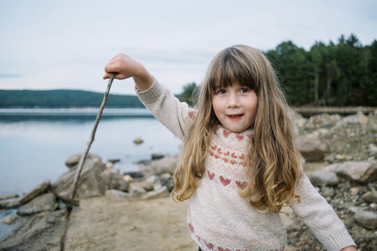 happy Little toddler girl with bands playing at a New England lake
