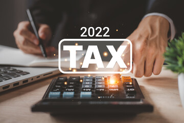 Tax 2022 of Individual income paid and corporations concept. Businessman using a calculator and laptop (notebook) of Data analysis, Paperwork, financial research, and report.
