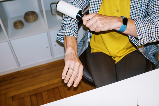 lo-fi flash image of middle-aged woman cleaning lint off her blazer