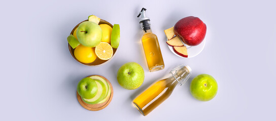 Composition with bottles of apple cider vinegar and fresh fruits on light background, top view