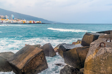White sea foam around a breakwater in the Atlantic Ocean off the coast of Puerto de la Cruz, Spain....