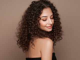 Fashion studio portrait of beautiful smiling woman with afro curly hairstyle. Fashion and beauty