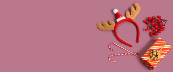 Christmas gift, candy canes and reindeer horns on color background with space for text