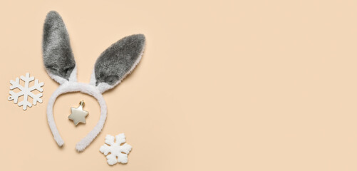 Bunny ears and Christmas decor on beige background with space for text