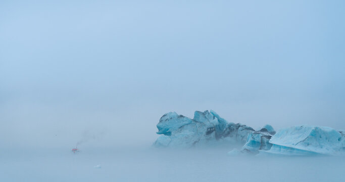 Icebergs floating in the ocean on a foggy day